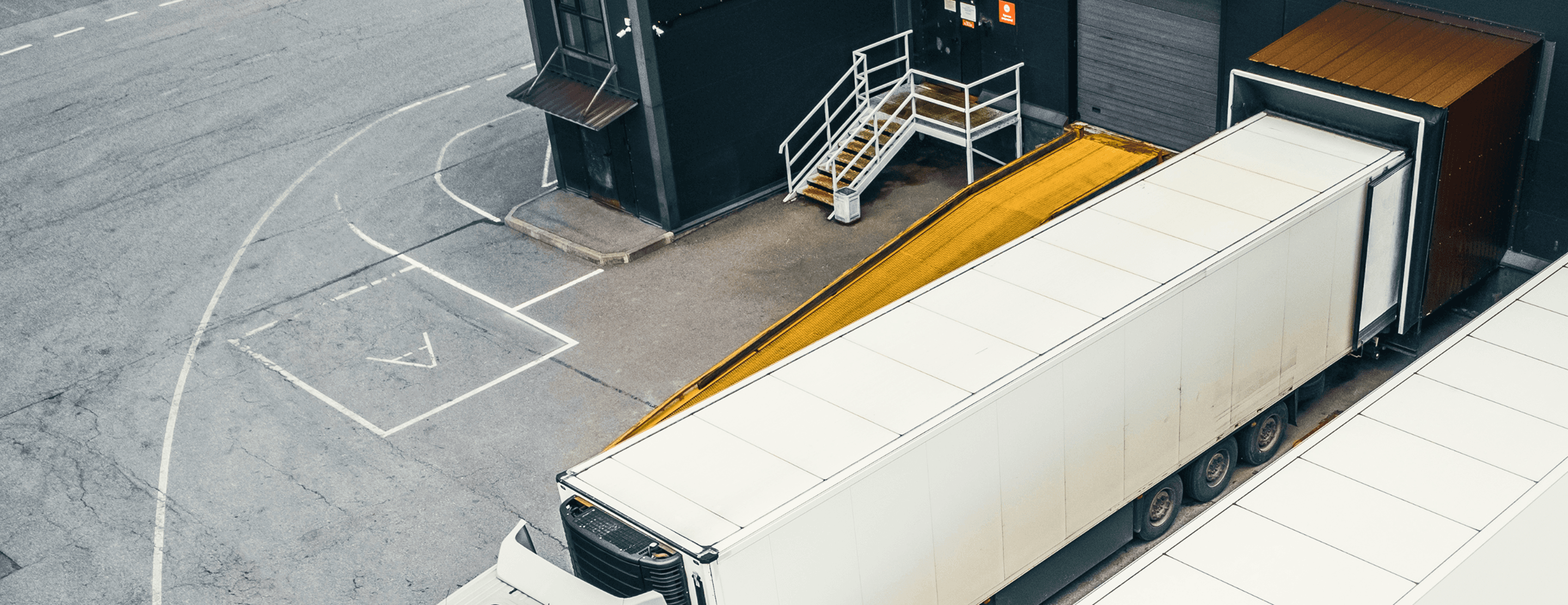 Semi truck backed into a loading dock for fleet transportation services